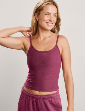 A smiling blonde woman wearing a heathered dusty rose pink ribbed camisole tank top and matching sweatpants, photographed against a light gray studio background.