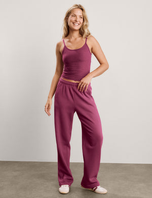 A smiling blonde woman wearing a heathered dusty rose pink ribbed camisole tank top and matching sweatpants, photographed against a light gray studio background.