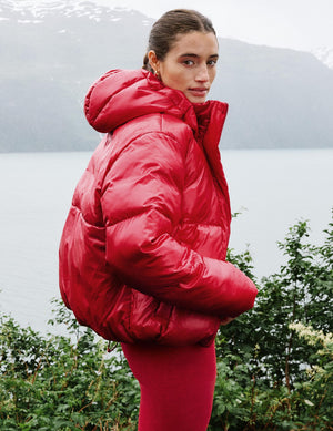 Woman wearing a red puffer jacket and red leggings. 