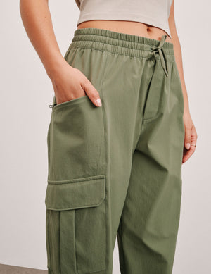Olive Peak Pant featuring a gathered elastic waistband with drawcord and utility cargo pockets on the side.