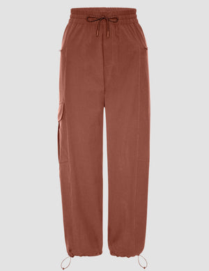 Brown Peak Pant featuring a gathered elastic drawstring waist, side cargo pockets, and adjustable bungee toggle hems.