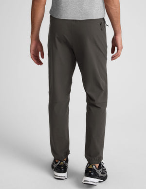 dark gray joggers and a grey t-shirt on a plain background. 