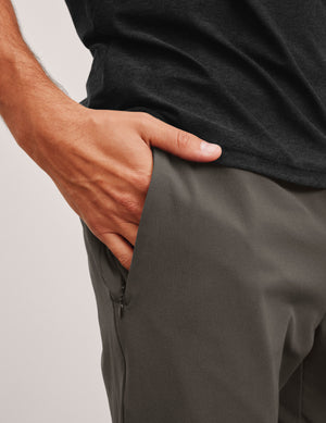 dark gray joggers and a grey t-shirt on a plain background. 