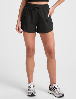 black cargo shorts worn by a person on a white background. 