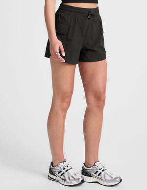 black cargo shorts worn by a person on a white background. 