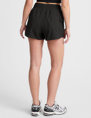 black cargo shorts worn by a person on a white background. 