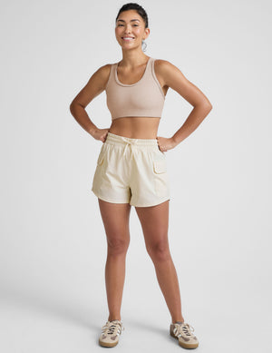 white mid-rise shorts with two side patch cargo pockets and a drawcord at waistband. 