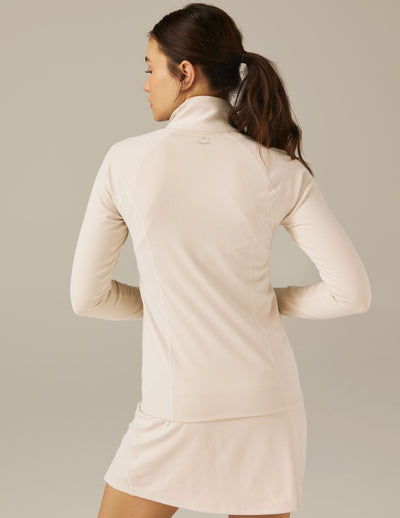 beige long sleeve top with quarter zip and thumb hole detail