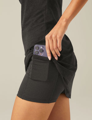 black mini dress with slim adjustable straps and built-in shorts with pockets. 
